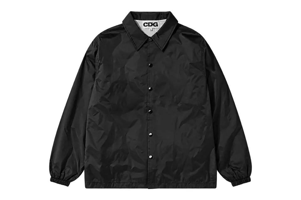 A black CDG coach jacket, isolated from its official product photograph.