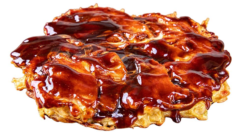 Kiji’s sauce-glazed okonomiyaki with bonito flakes, isolated on a transparent background.