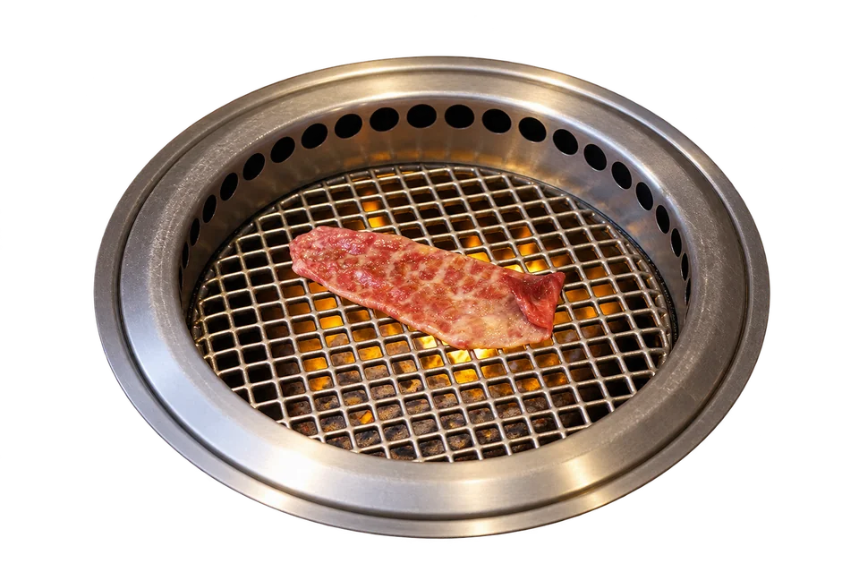 Beef grilling over charcoal at Yoroniku.